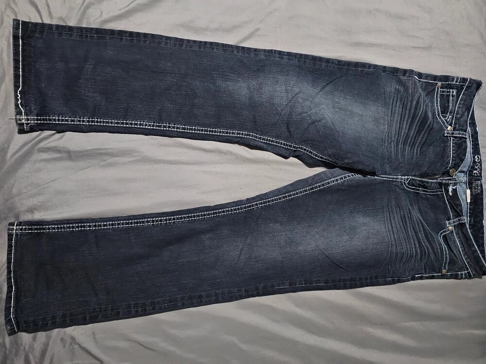 Dark wash denim jeans with contrast stitching whiskering and zip fly
